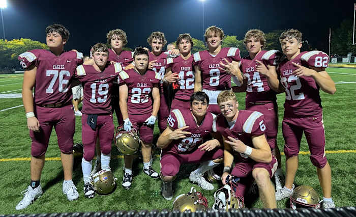 Jake Uhlenhake (No. 8) and Ben Uhlenhake (No. 42) pose with some of their teammates following a Bishop Watterson win.